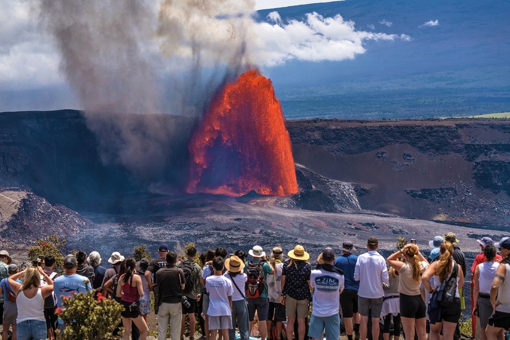 ハワイ火山国立公園でキラウエア火山の噴火を見る旅行者